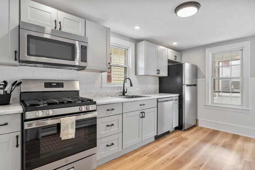 Kitchen remodel with white cabinets and marble backsplash in Maine