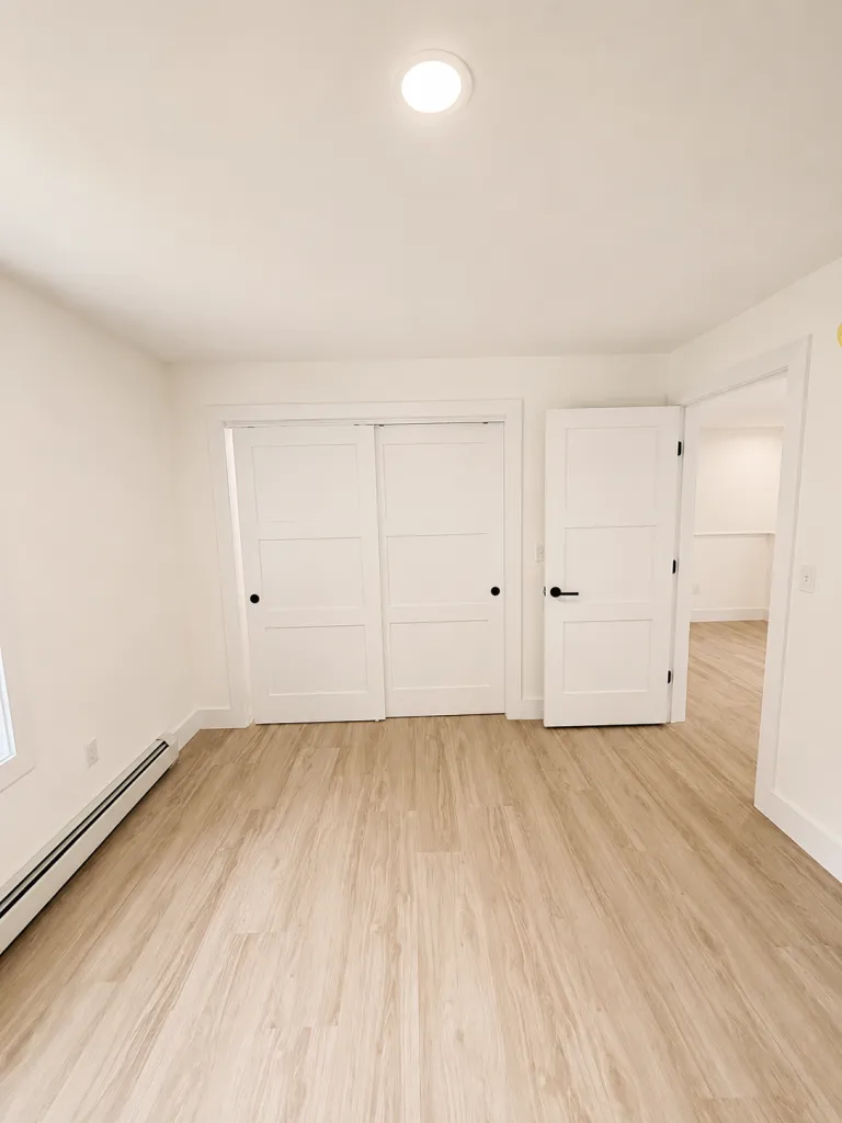 Finished bedroom with double closet and vinyl plank flooring in new construction in Maine